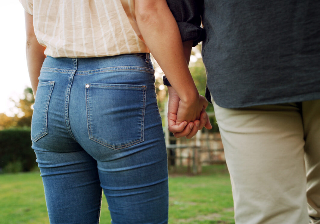 Holding hands, back and couple outdoor for connection, trust and marriage with bonding in garden. People, love and care with support, commitment and walking date in nature for healthy relationship